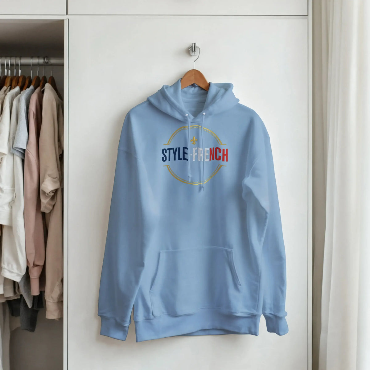 sweatshirt à capuche qualité supérieure France suspendu dans un placard avec un logo coloré